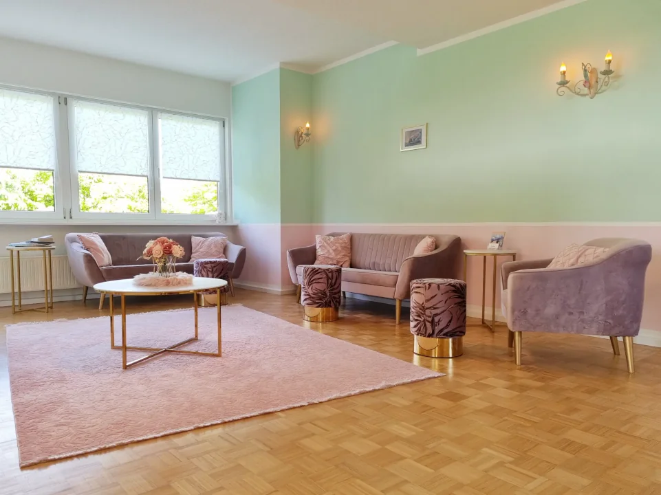 Einladender Wartebereich der Praxis BE HEALED mit stilvollen Möbeln in Rosé und Gold